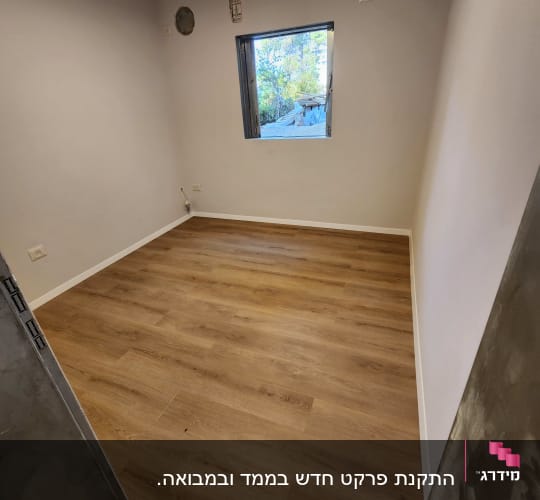 חדר עם רצפת פרקט עץ וחלון פתוח